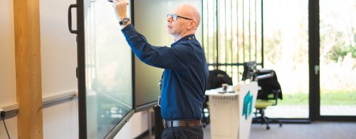 Associate Professor Peter Metcalfe delivering training - writing on a digital white board