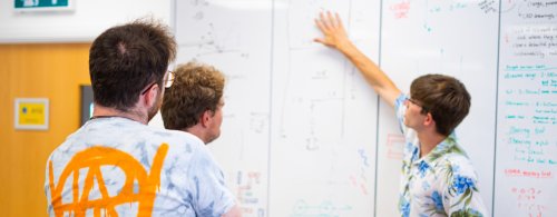 NMITE Students in a studio making calculations on a whiteboard 